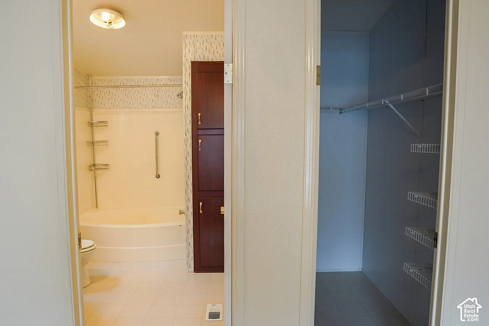 Bathroom featuring a built-in tub, ceramic tile flooring, and a dark wood-finish cabinet