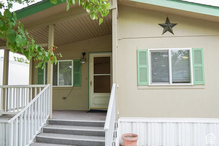 Covered porch with white railings and gray steps