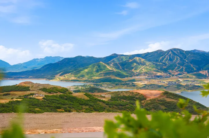 Expansive mountain and lake scenery with distant ski slopes