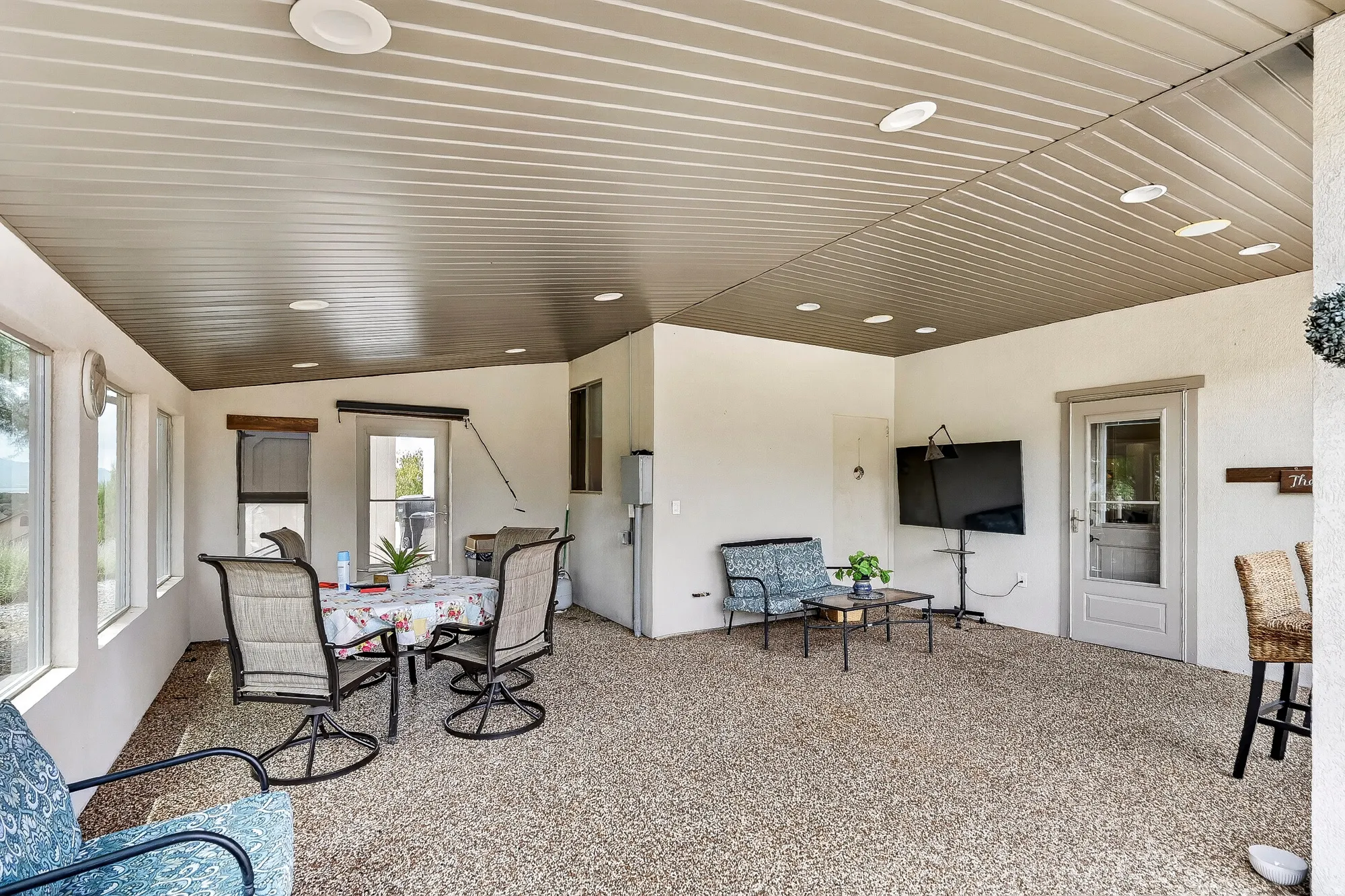 Spacious open-concept living area featuring recessed ceiling lighting, neutral wall finishes, and expansive carpeting