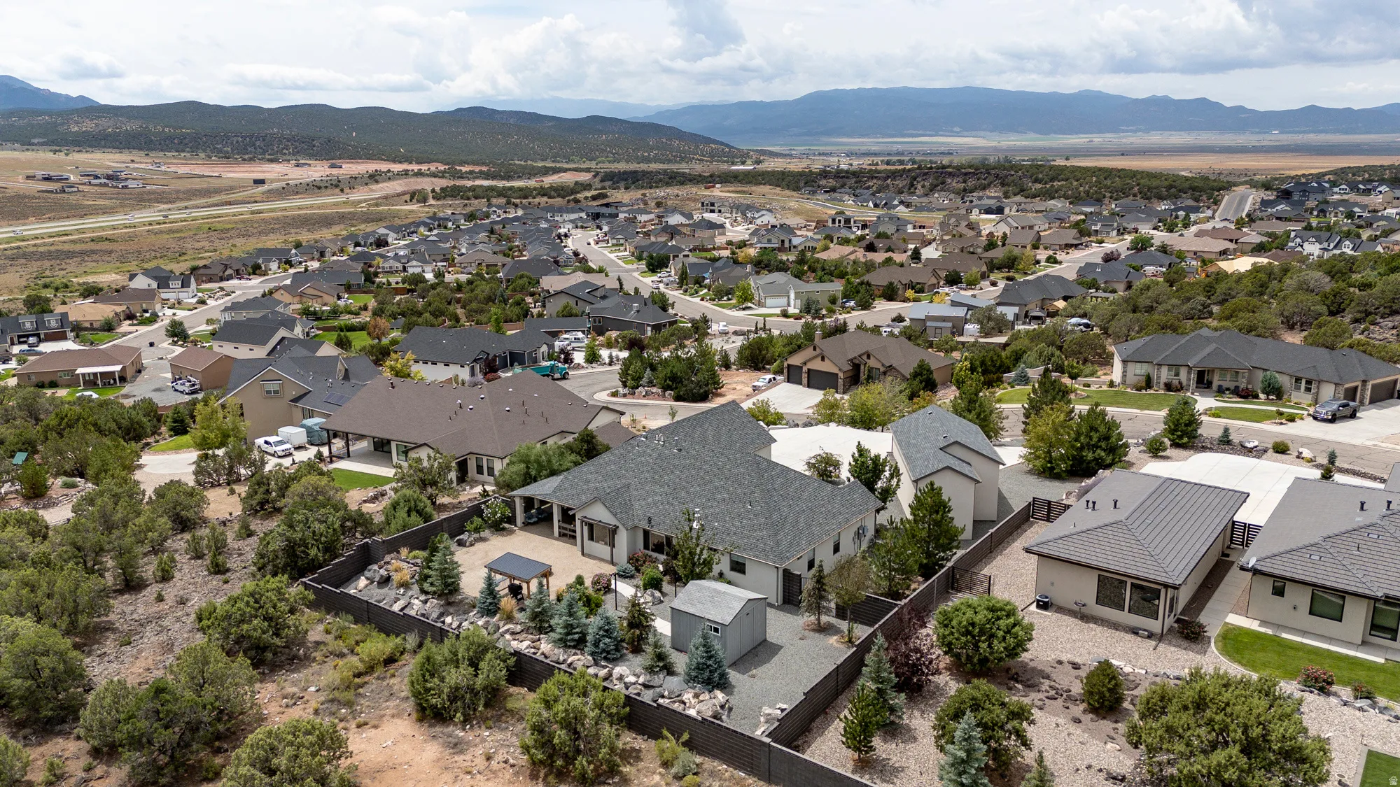 Expansive residential community featuring a variety of single-family homes with diverse architectural styles, surrounded by natural desert landscaping and distant mountains