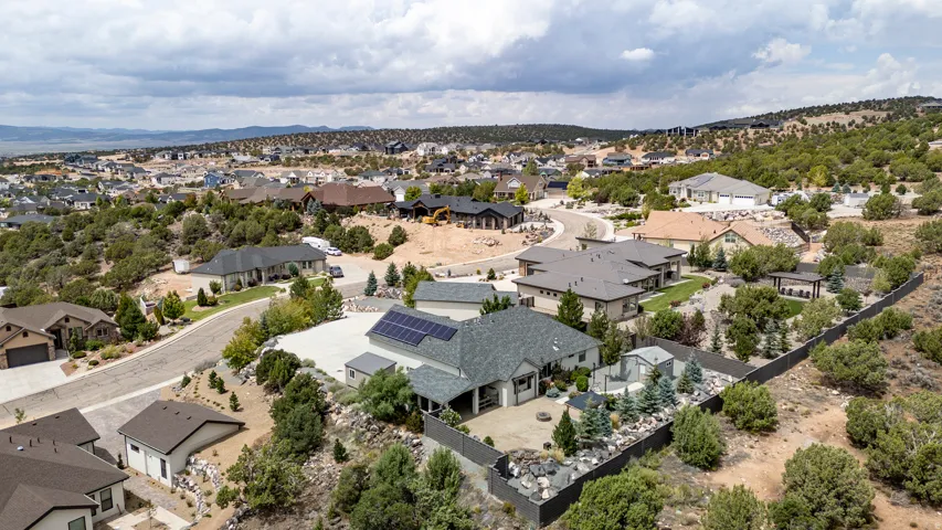 Extensive property with a large patio area, integrated solar panels, and a surrounding privacy fence