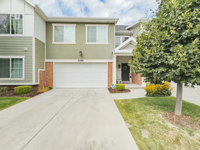 Two-story residence featuring a covered entry, attached garage, and a concrete driveway