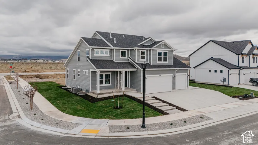 Contemporary two-story residence with gray siding, white trim, and a dark shingle roof
