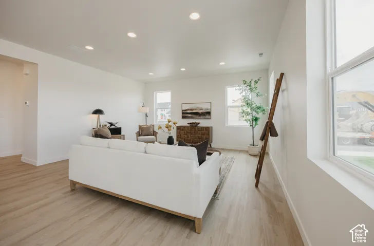 Recessed ceiling lighting, light wood-finish flooring, multiple windows, and crisp white walls