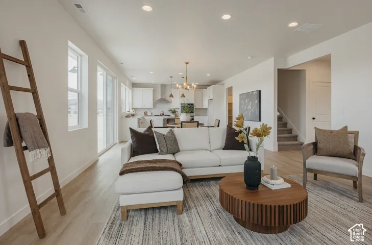 Open-concept living space featuring wood-finish flooring, recessed lighting, and white walls