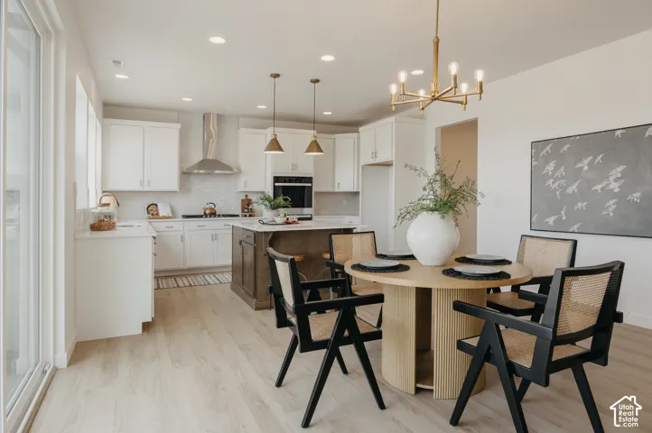 Kitchen with white cabinetry, stainless steel appliances, wood-finish flooring, and a central island