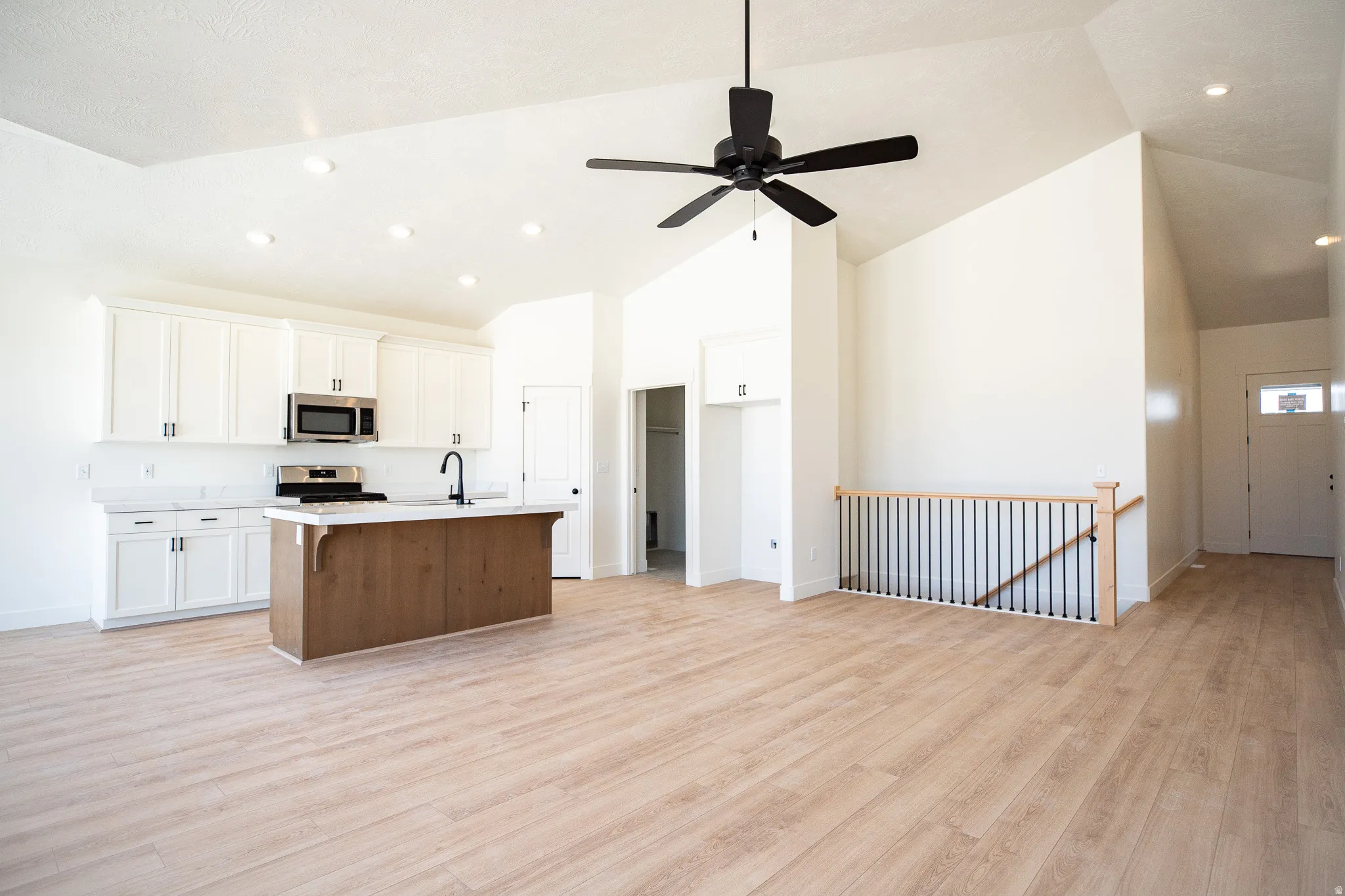 Family/Great room with vaulted ceiling and ceiling fan.