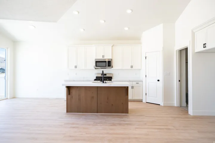 Terrific kitchen with 42" uppers, painted white wood cabinets, stained wood island, quartz slab countertops, gas range, microwave, dishwasher and disposal.