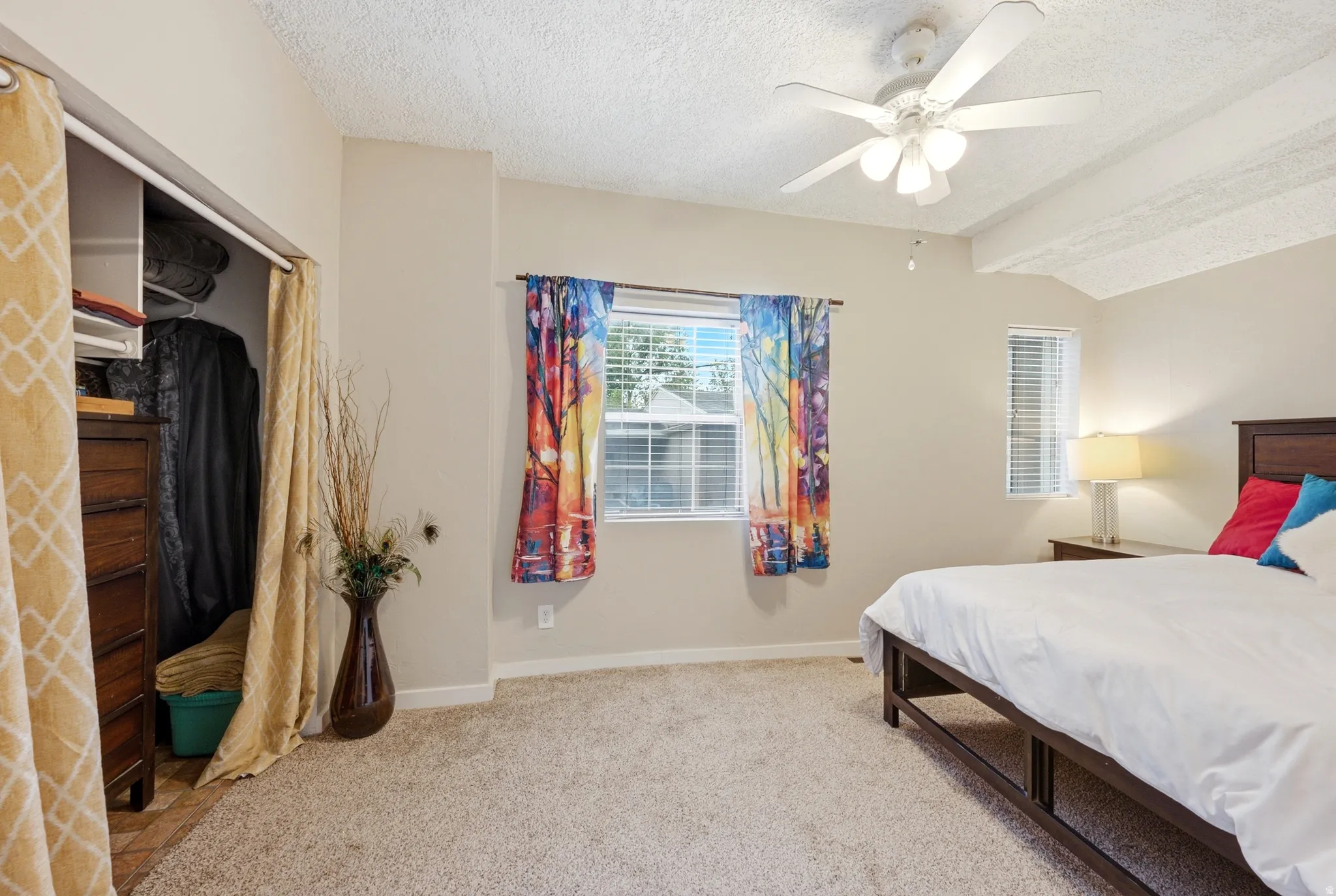 Carpeted flooring, vaulted ceiling with exposed beams, ceiling fan with light fixture, window with blinds
