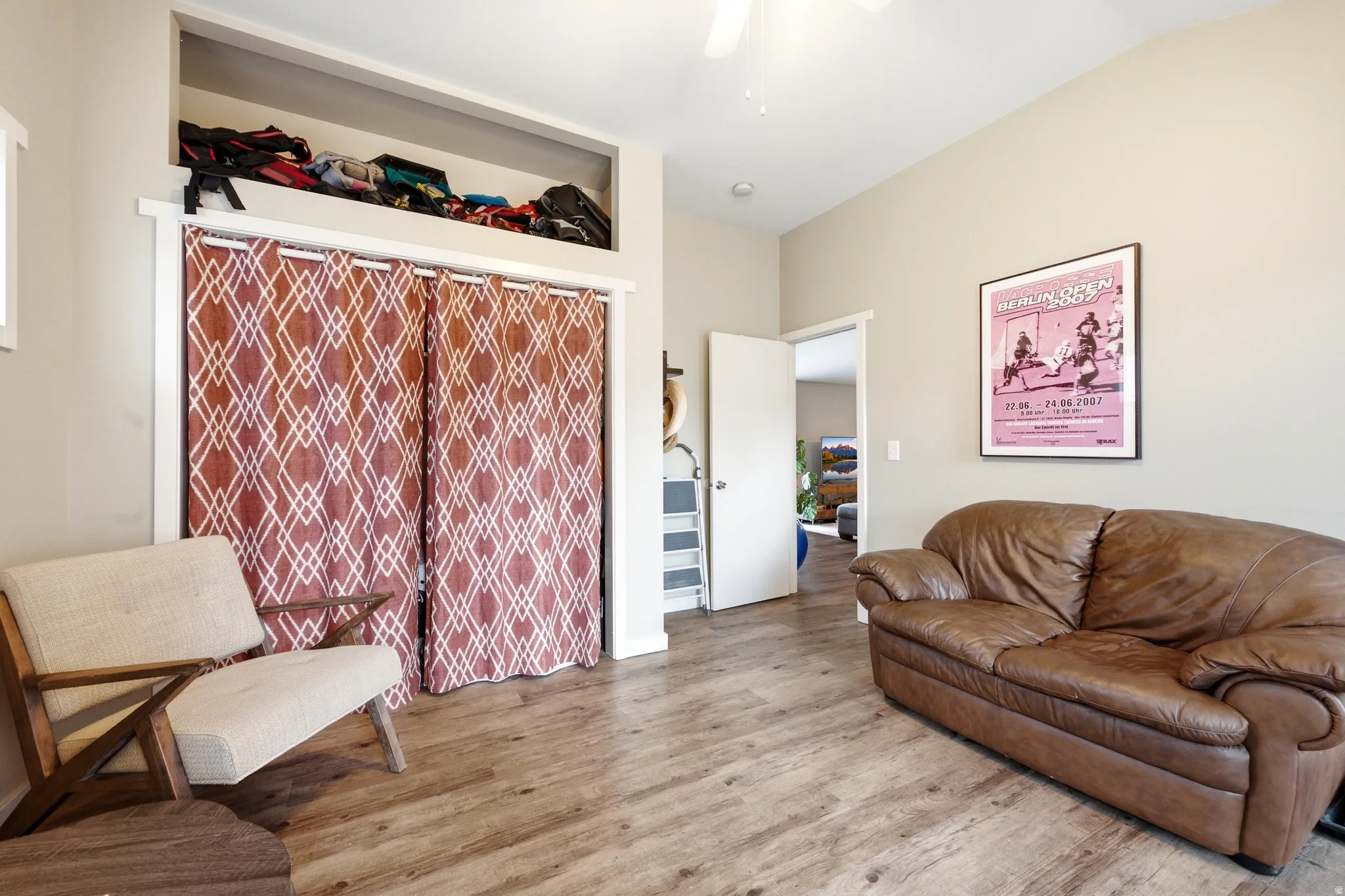 Vaulted ceiling, wood-finish flooring, built-in open shelving, and neutral wall tones