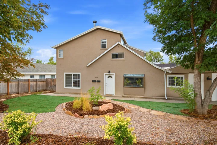 Stucco exterior with multiple window styles, central front door, and a bay window feature