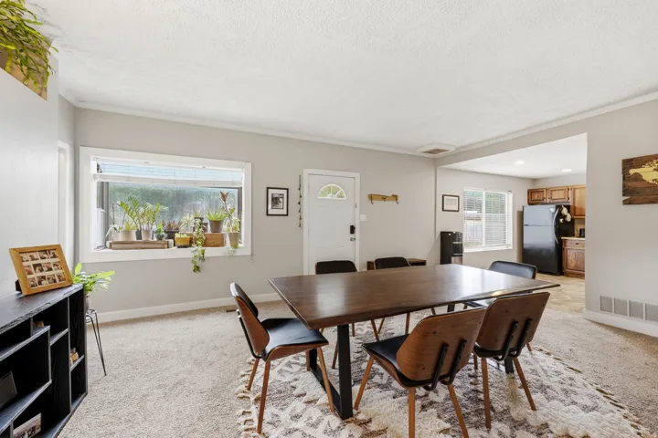 Carpeted common area with light gray walls, white trim, and a white front entry door