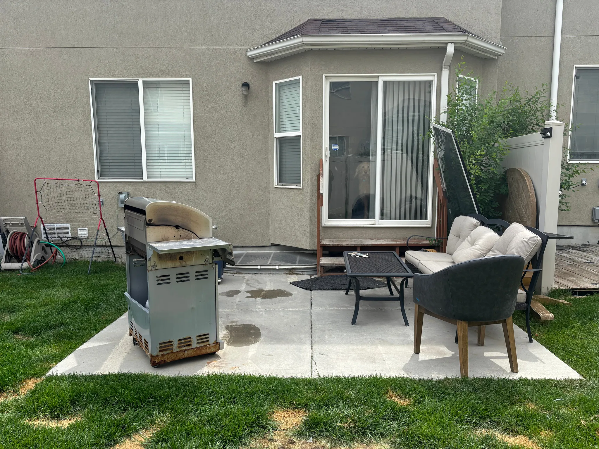 Concrete patio with a stucco exterior and sliding glass door