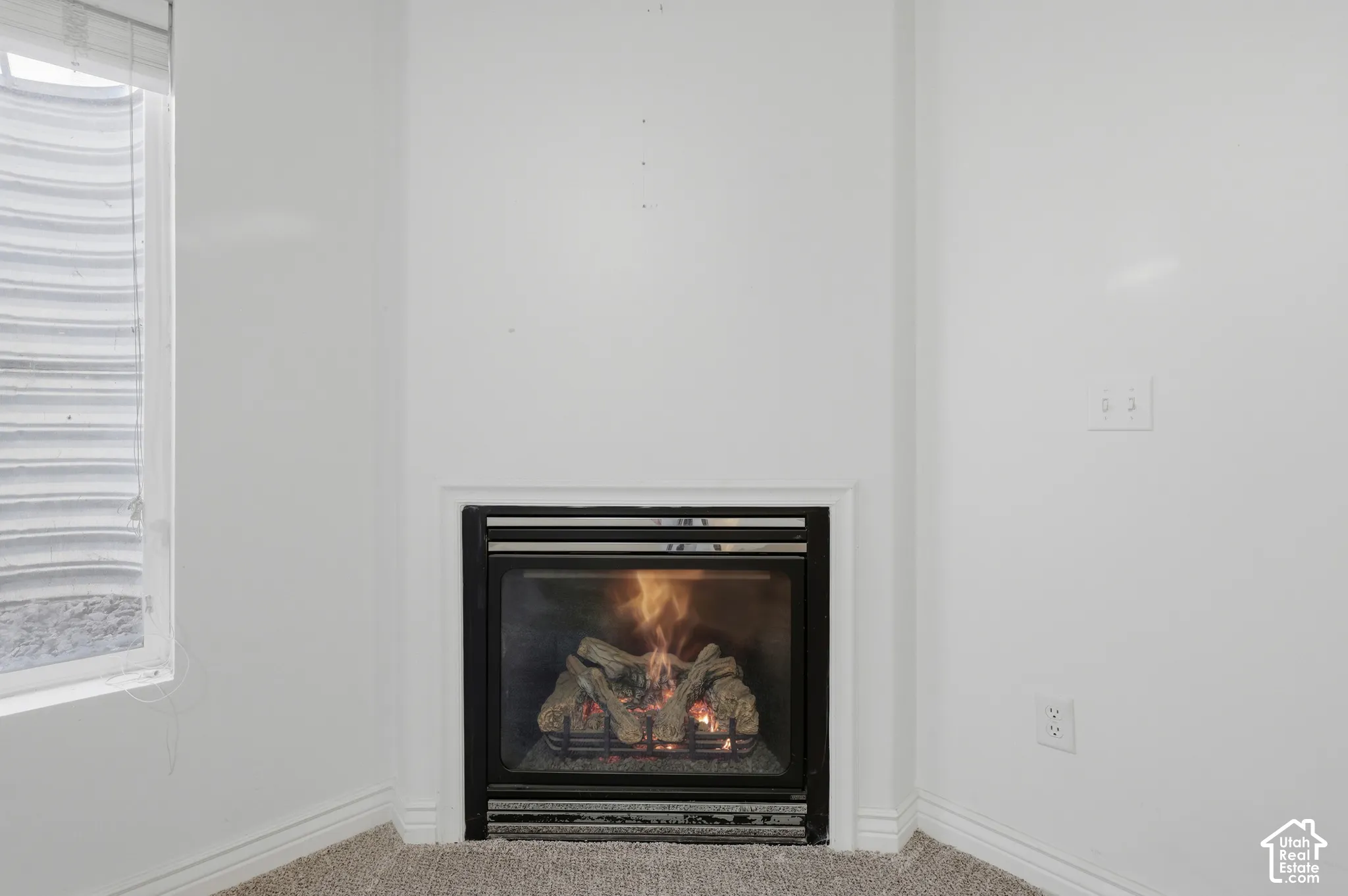 Built-in fireplace with a black glass enclosure and corner placement