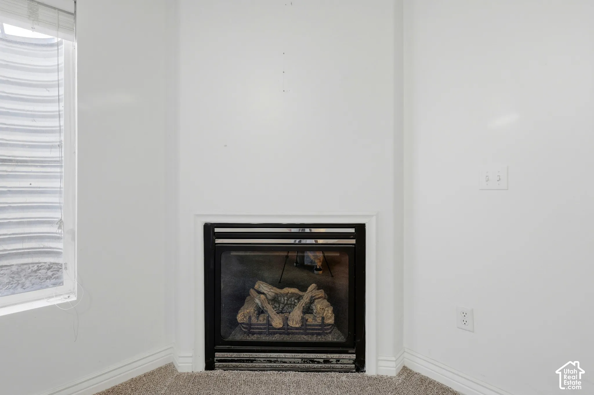 Built-in fireplace with log inserts, framed by a white mantel