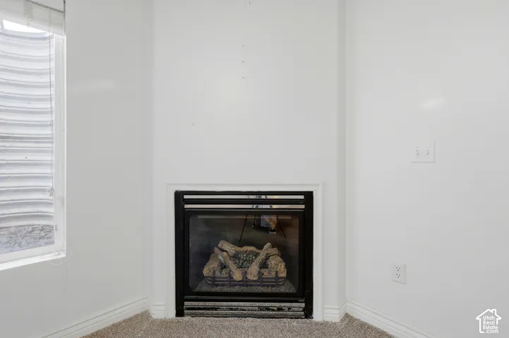 Built-in fireplace with log inserts, framed by a white mantel