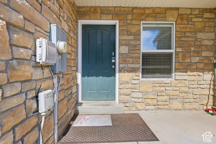 Stone veneer exterior with a paneled entry door and single-pane window