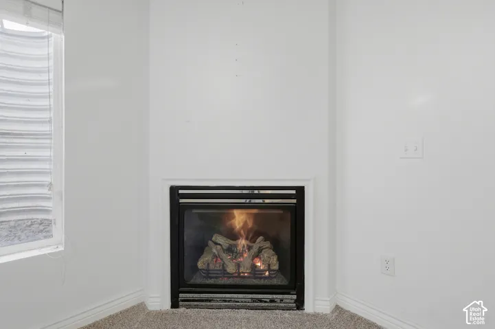 Built-in fireplace with a black glass enclosure and corner placement