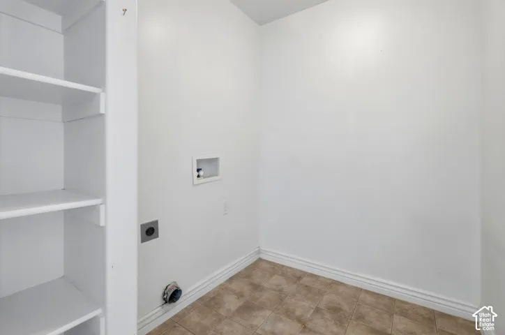 Built-in shelving, tile flooring, and utility hookups