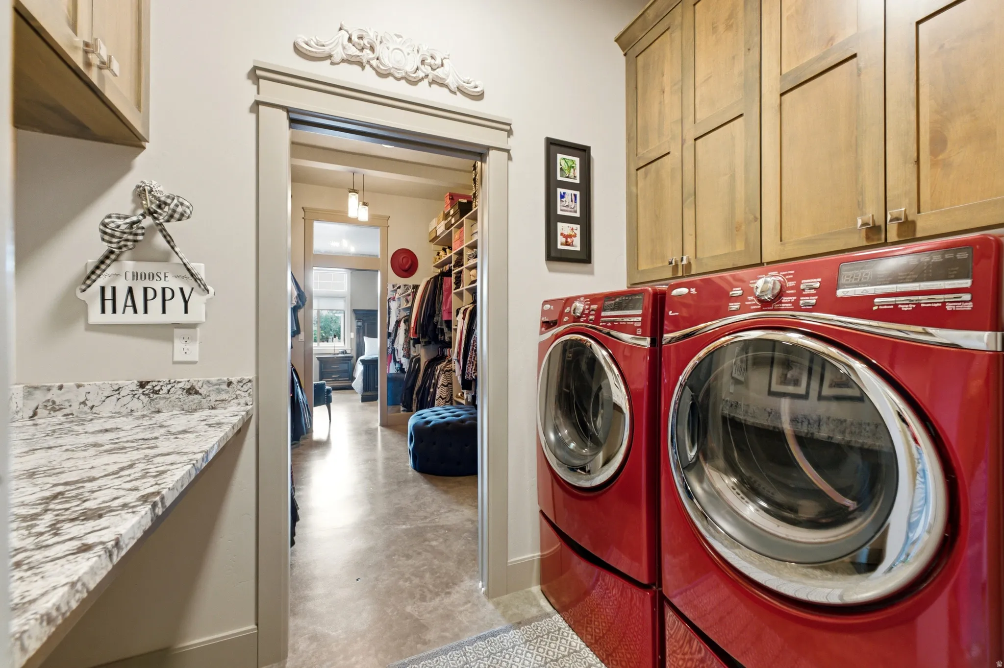 Laundry area featuring wood-finish cabinetry, a patterned stone countertop, and decorative trim