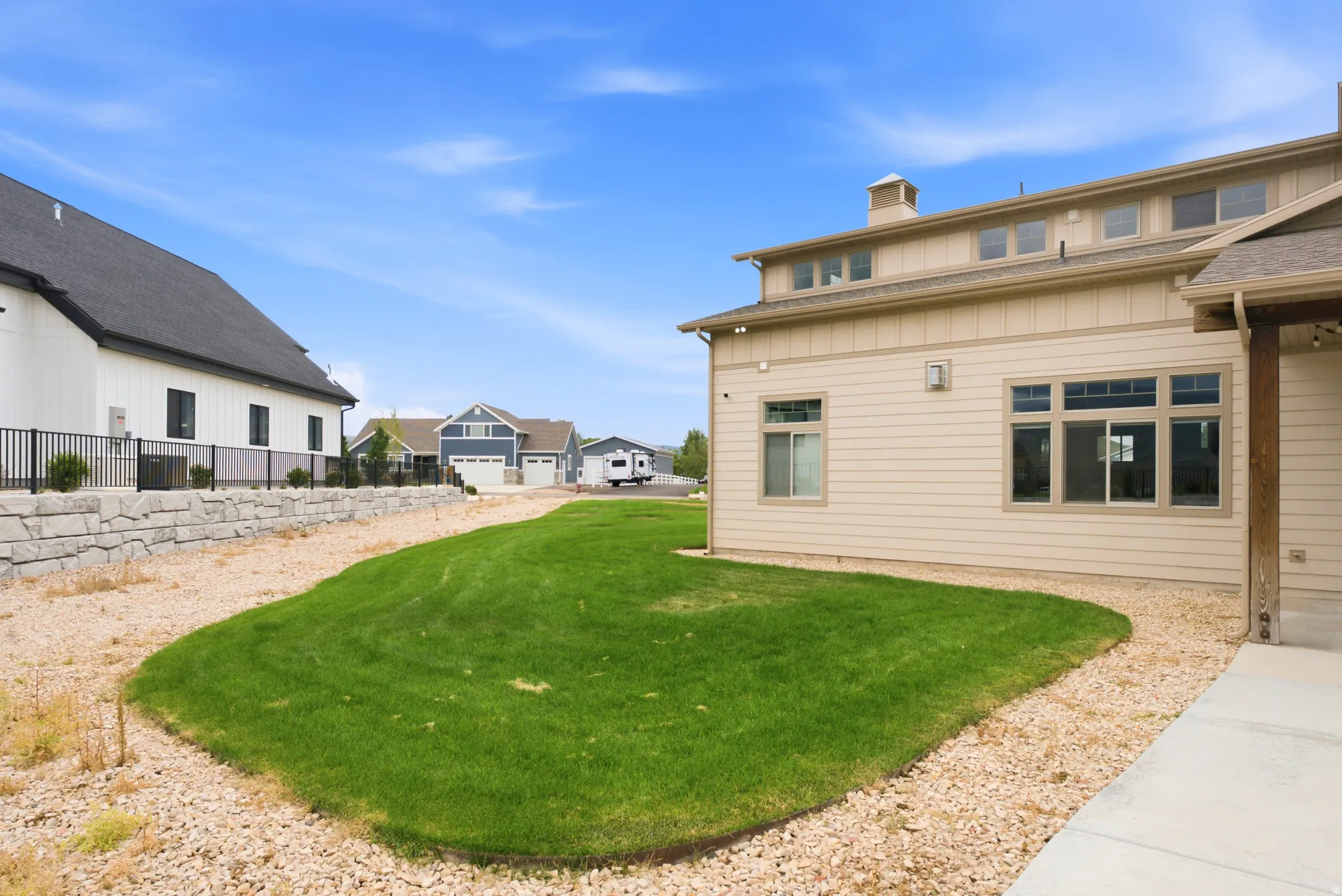 Manicured lawn with gravel landscaping and a stone retaining wall