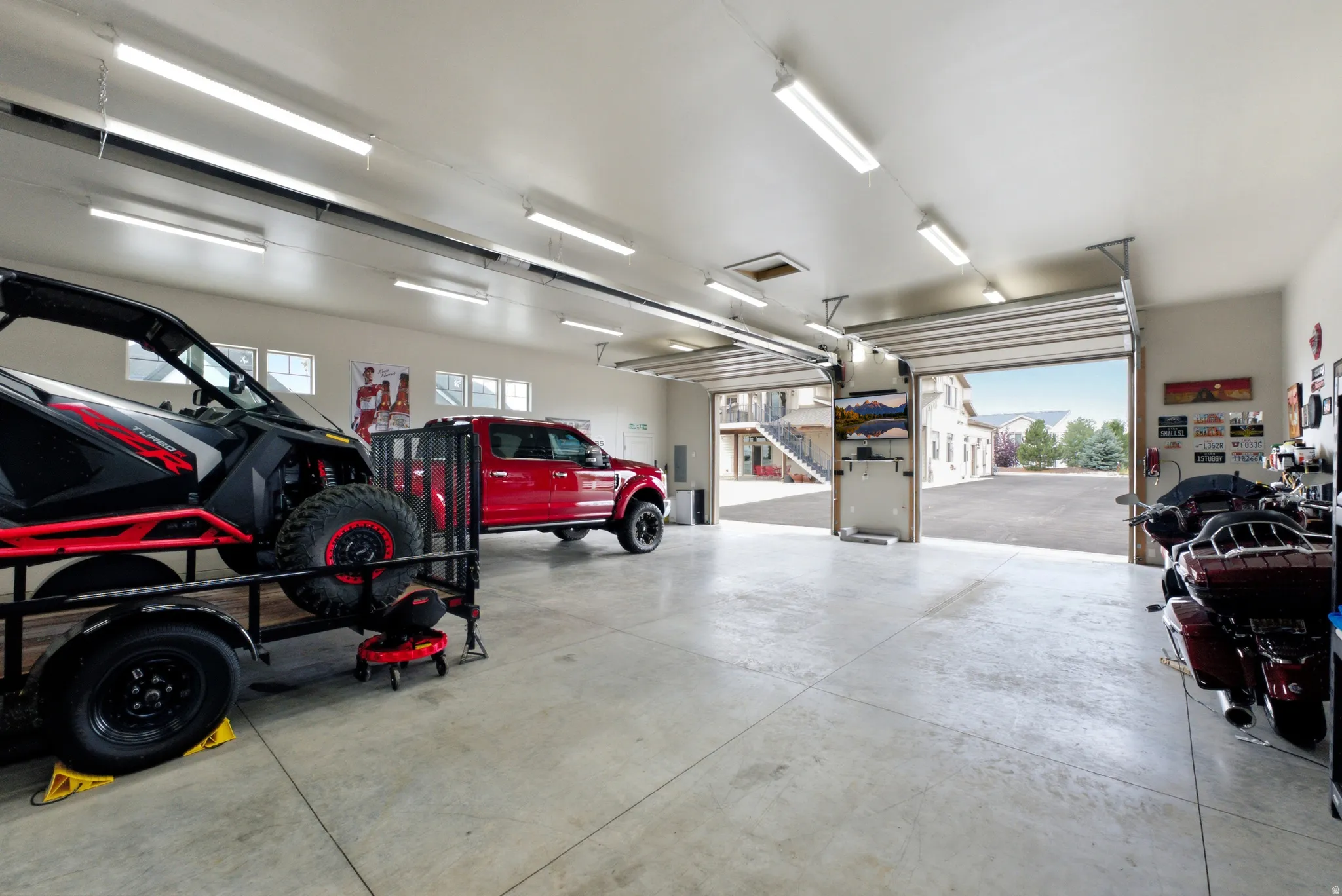 Spacious garage with multiple overhead doors, concrete flooring, and ample overhead lighting