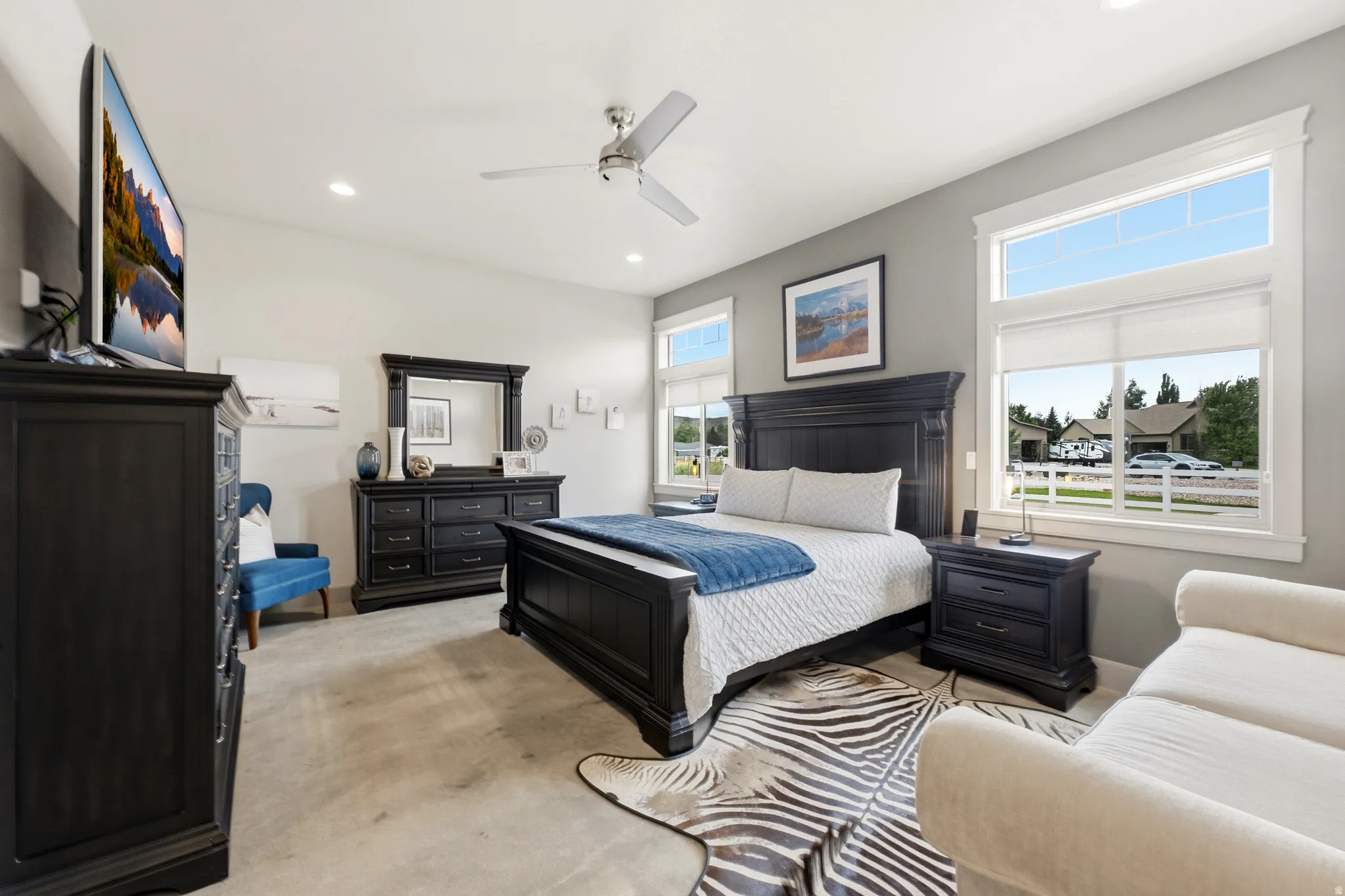 Vaulted ceiling with a ceiling fan, recessed lighting, and multiple windows with white trim