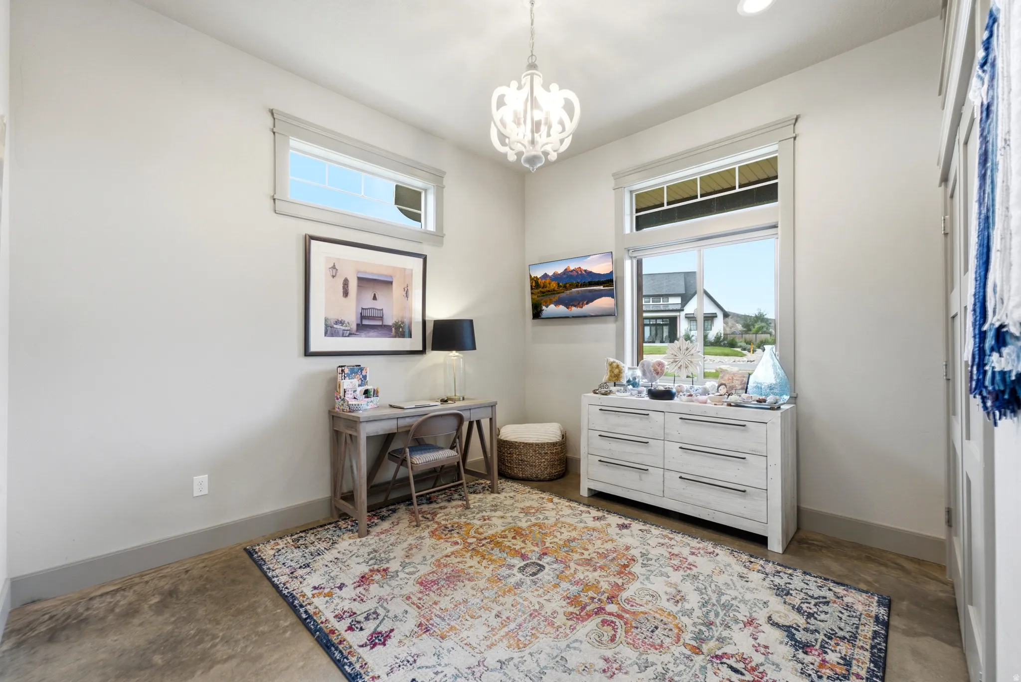 Recessed lighting, a decorative chandelier, and an overhead window illuminate the space