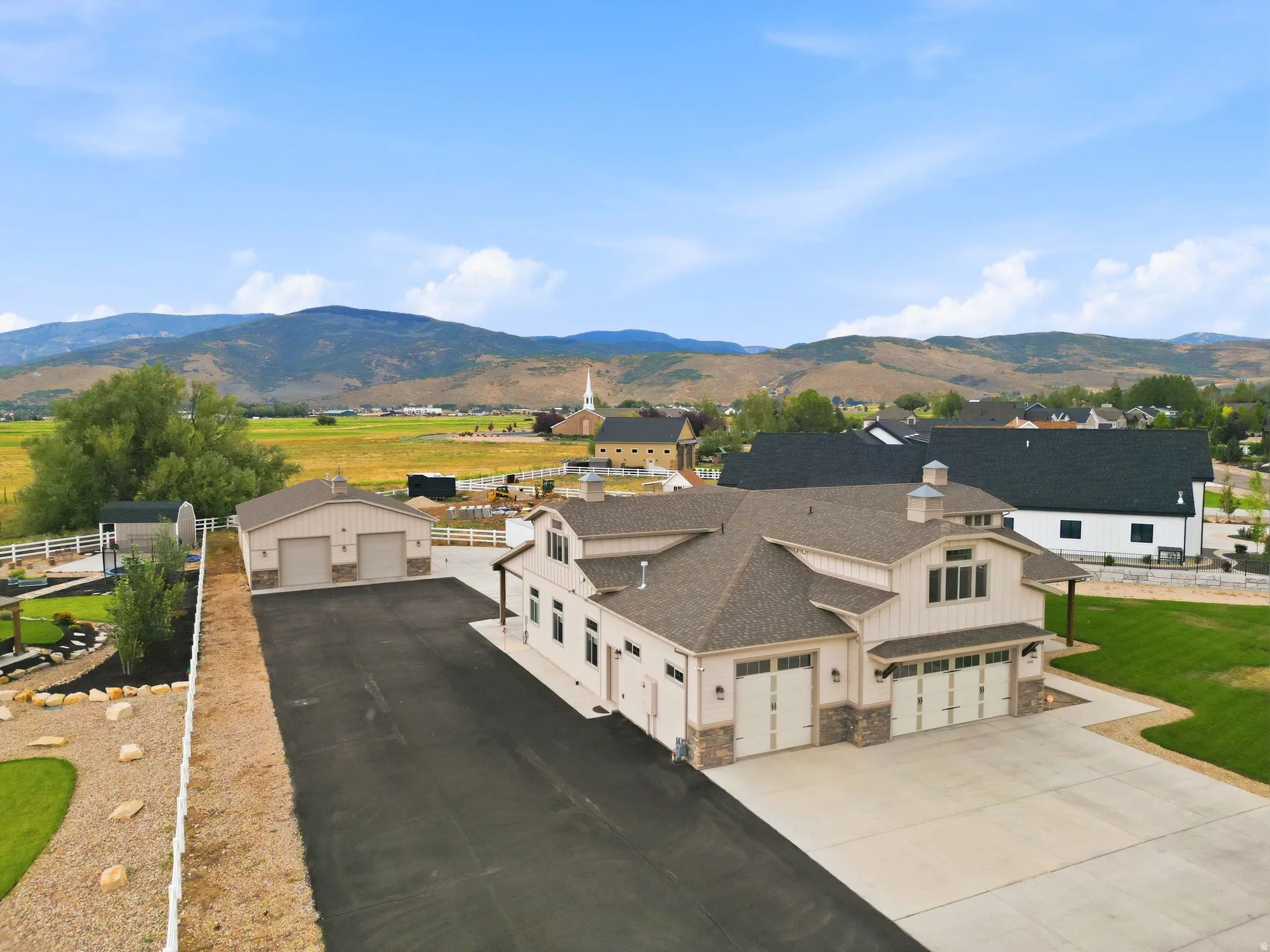 Stunning modern farmhouse with expansive asphalt driveway and three-car garage