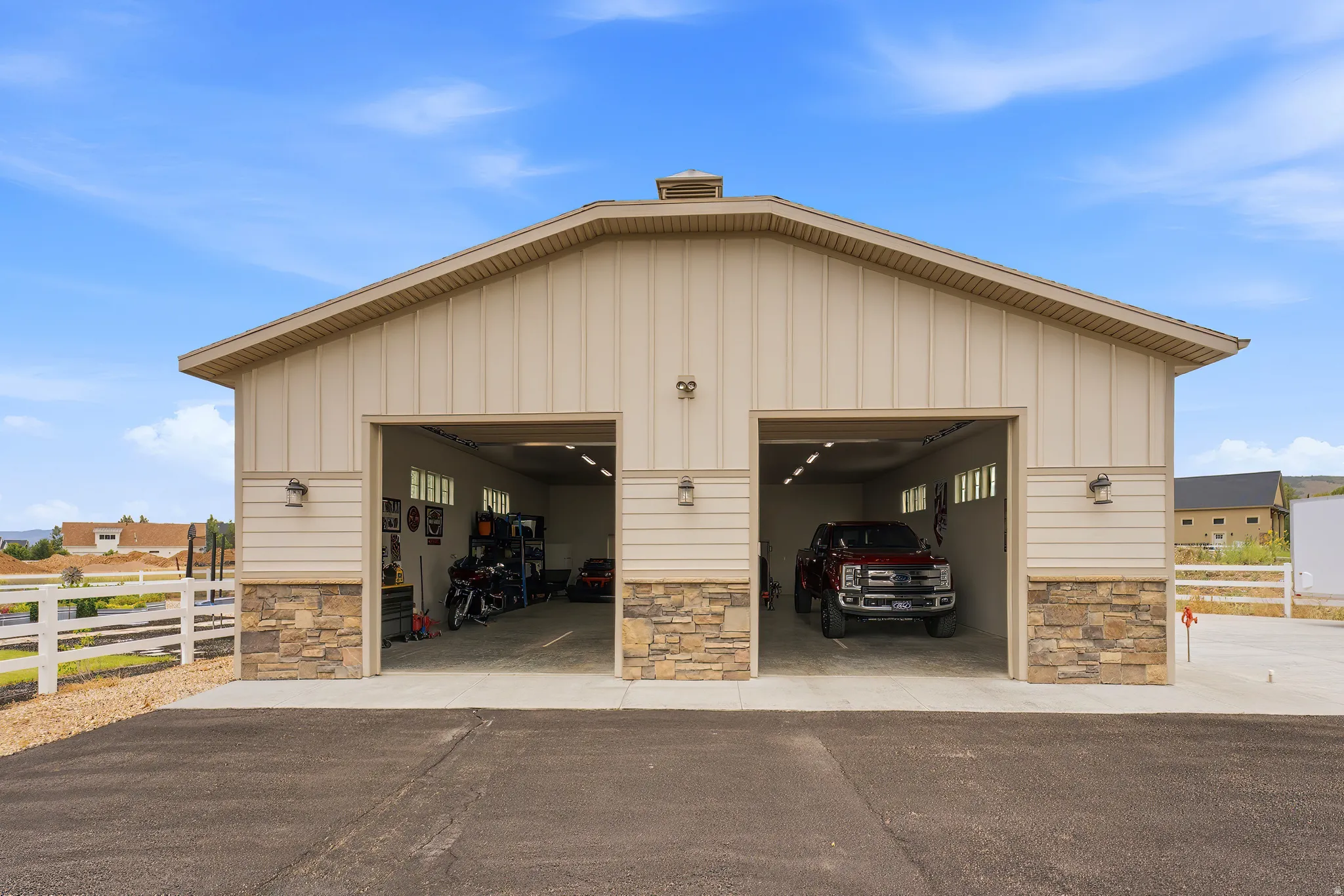 Two-bay garage with exterior stone wainscoting and vertical siding