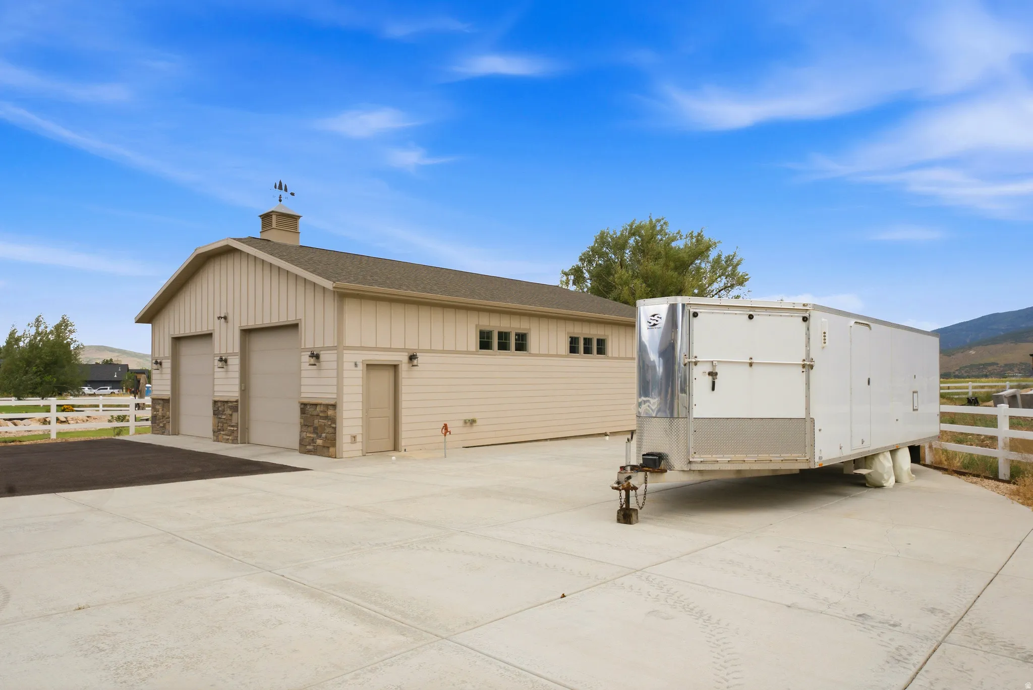 Detached garage featuring dual bay doors and stone facade accents