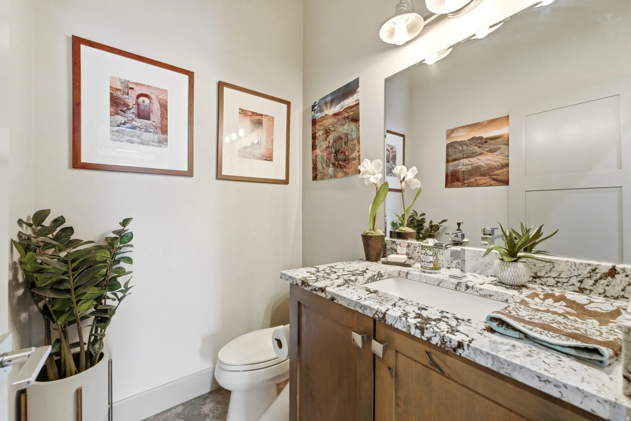 Spa-inspired bathroom featuring a wood-finish vanity with dual sinks, granite-look countertop, and polished chrome fixtures