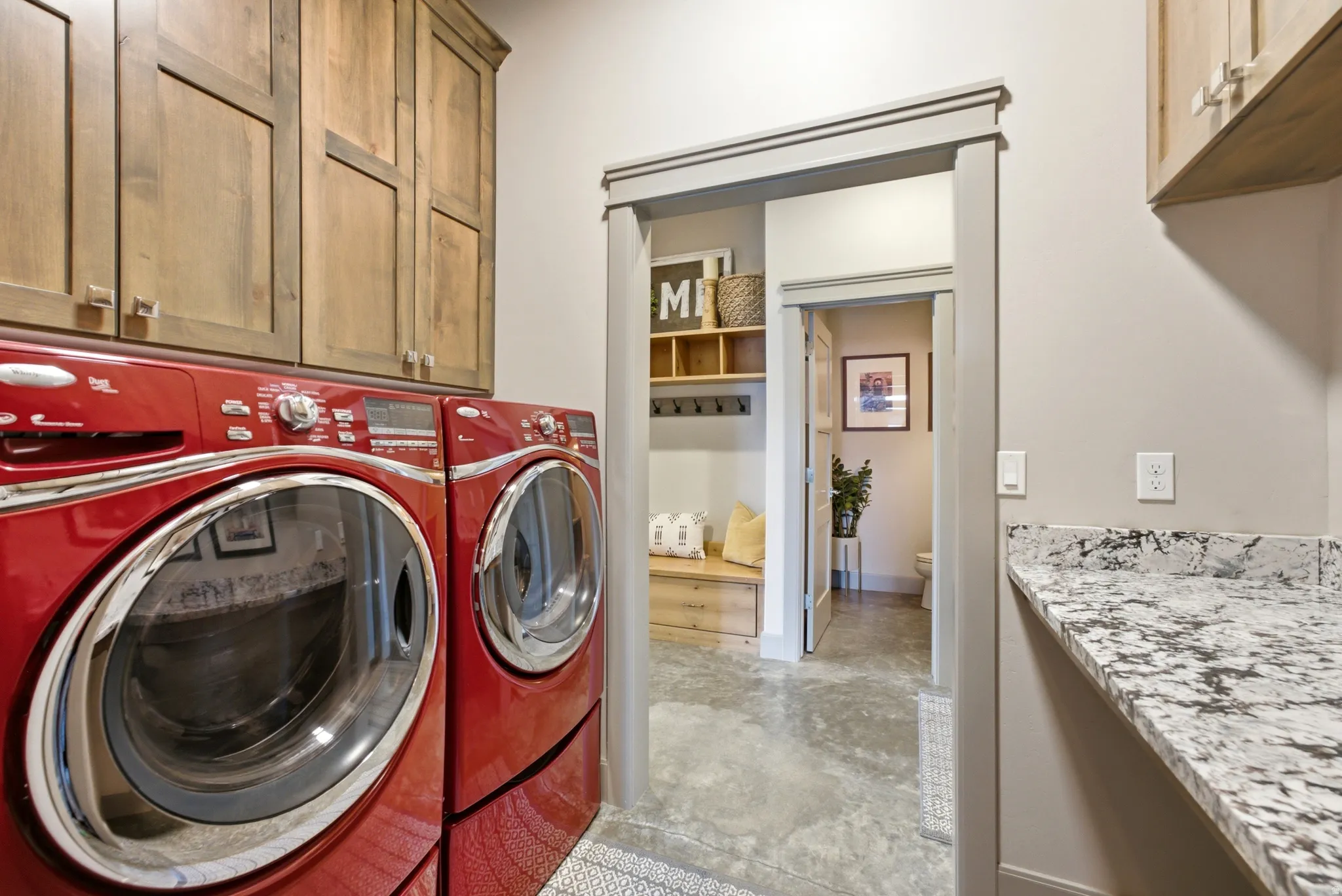Wood-finish upper cabinetry, light-toned walls, and a speckled countertop