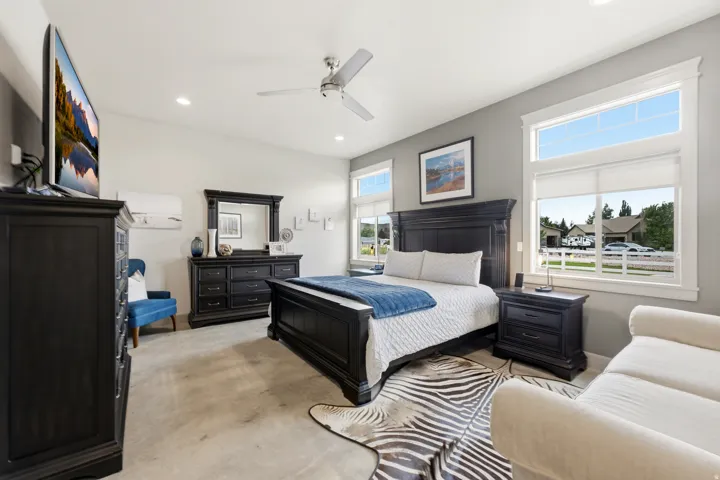 Vaulted ceiling with a ceiling fan, recessed lighting, and multiple windows with white trim