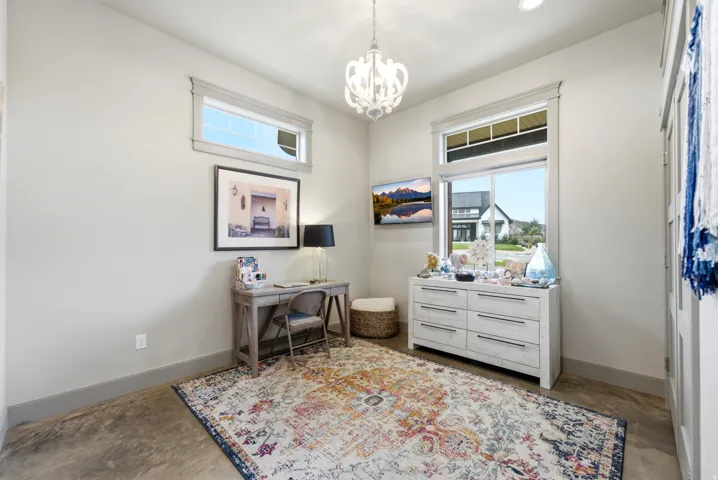 Recessed lighting, a decorative chandelier, and an overhead window illuminate the space