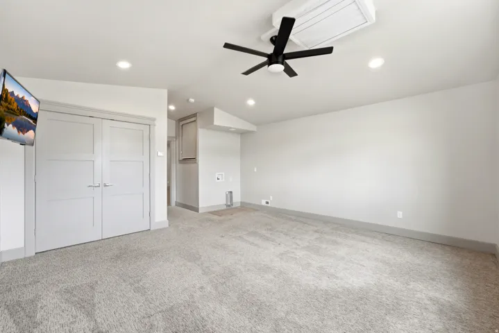 Vaulted ceiling with recessed lighting and a ceiling fan, carpeted flooring, and light-toned walls