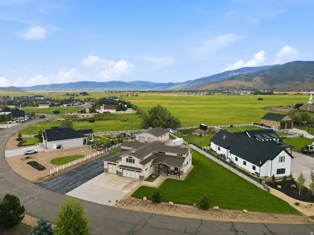Modern ranch-style residence featuring a multi-car garage, manicured lawn, and paved driveway