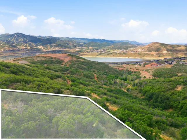Expansive mountain landscape with a prominent lake, surrounded by verdant hills and distant residential development