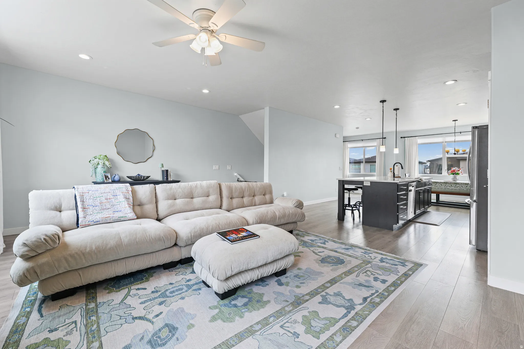 Recessed lighting, ceiling fan, wood-finish flooring, kitchen island, and stainless steel refrigerator