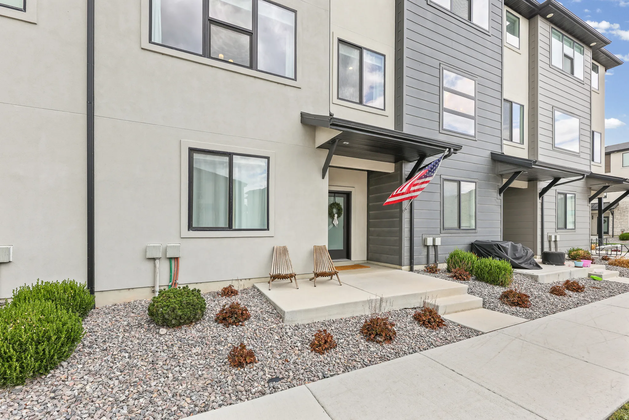 Contemporary façade with light-colored stucco and dark siding accents