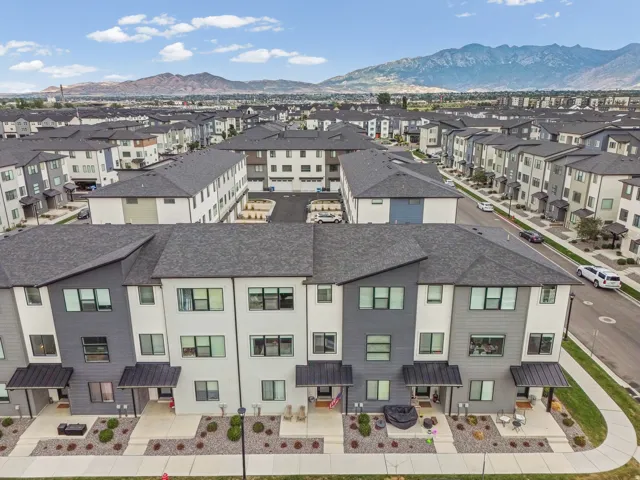 Modern townhome exterior featuring multi-toned siding, dark pitched roofs, and private entryways