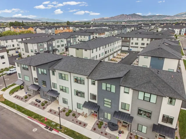 Modern multi-story facade featuring varied siding materials and dark-toned pitched roofs