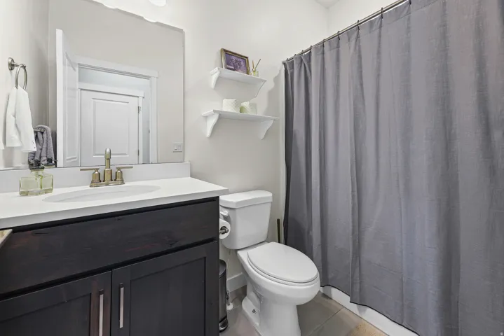Dark wood-finish vanity with a white countertop and oval sink
