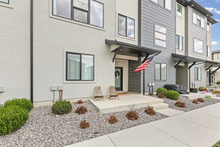 Contemporary façade with light-colored stucco and dark siding accents
