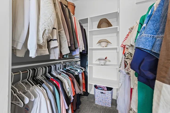 Built-in closet system featuring white shelving and hanging rods