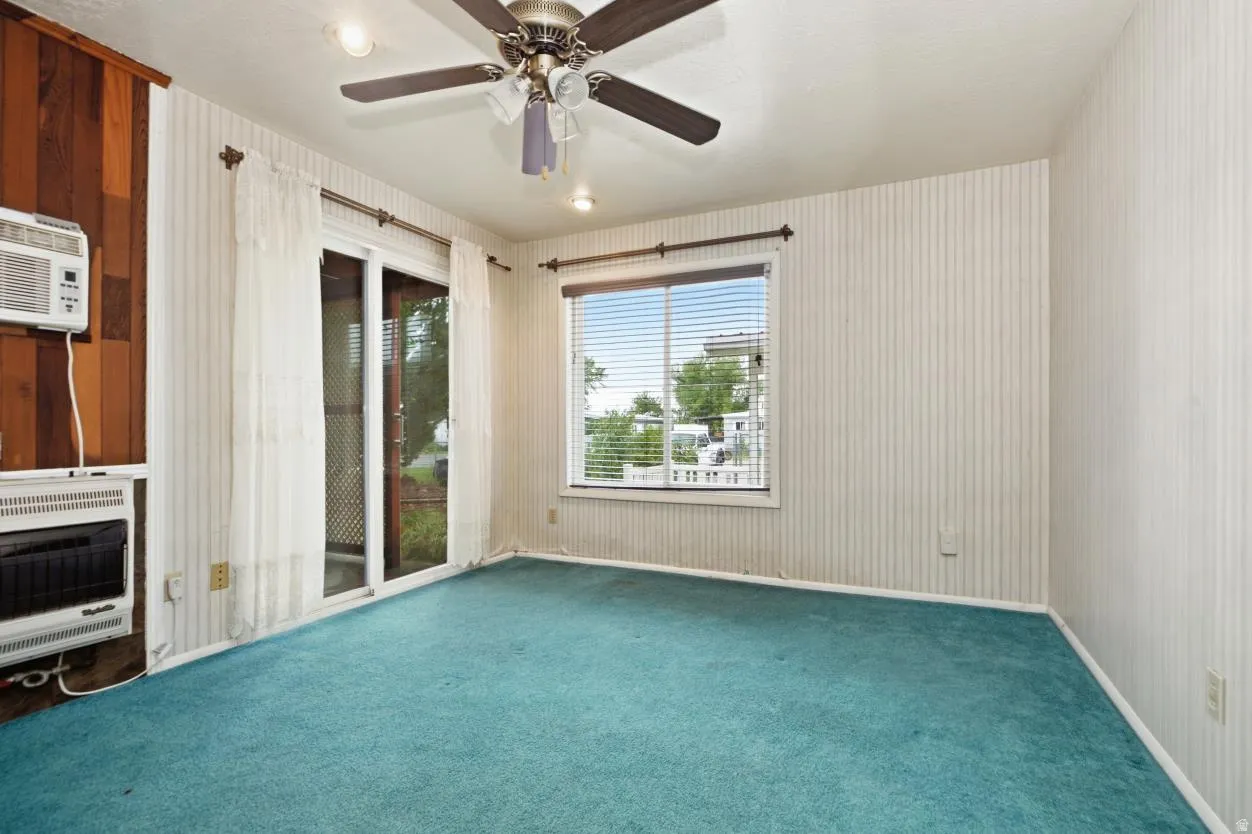 Spacious interior with a ceiling fan, recessed lighting, and a window with blinds