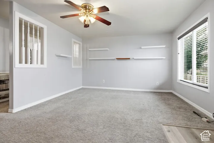 Recessed lighting with a ceiling fan, light gray wall paint, built-in shelving, white trim, and a window with blinds