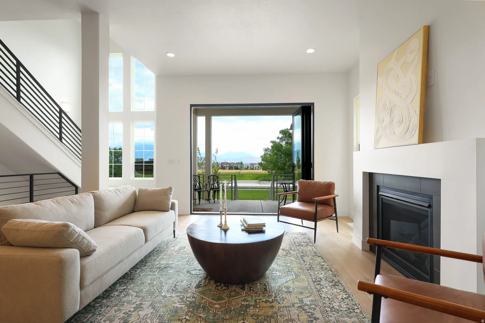 Spacious living area featuring a modern fireplace, light wood-finish flooring, and a multi-pane window configuration