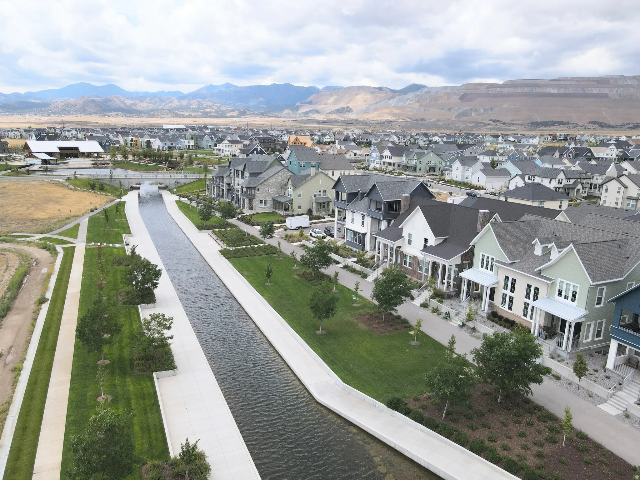Luxury residential community featuring elegant architectural design with multi-story homes, manicured landscaping, and a scenic waterfront canal system
